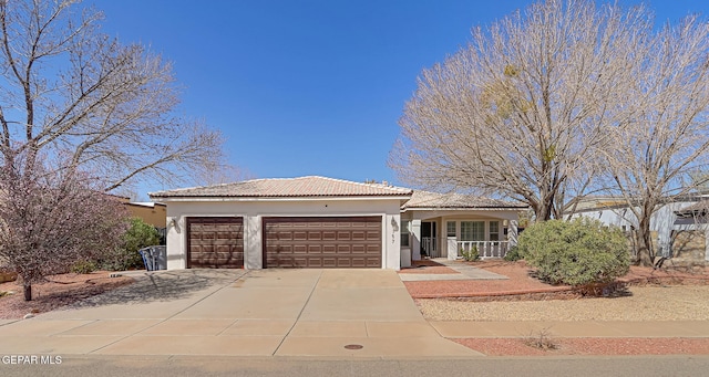 single story home with driveway, a porch, stucco siding, a garage, and a tiled roof