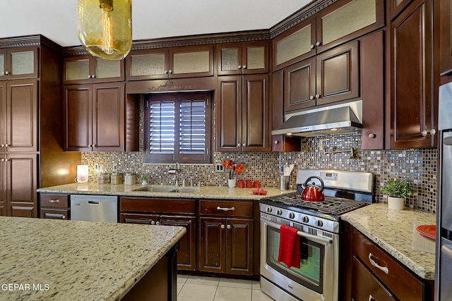 kitchen featuring under cabinet range hood, stainless steel appliances, backsplash, and a sink