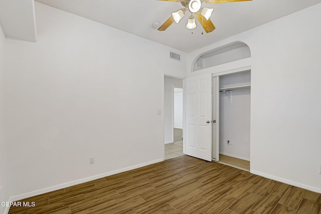 unfurnished bedroom featuring visible vents, a ceiling fan, wood finished floors, a closet, and baseboards