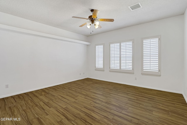 unfurnished room with visible vents, a textured ceiling, a ceiling fan, and wood finished floors