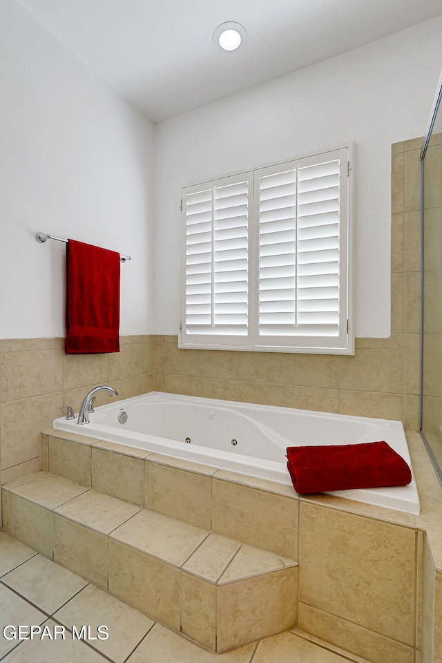 bathroom with tile patterned floors and a jetted tub