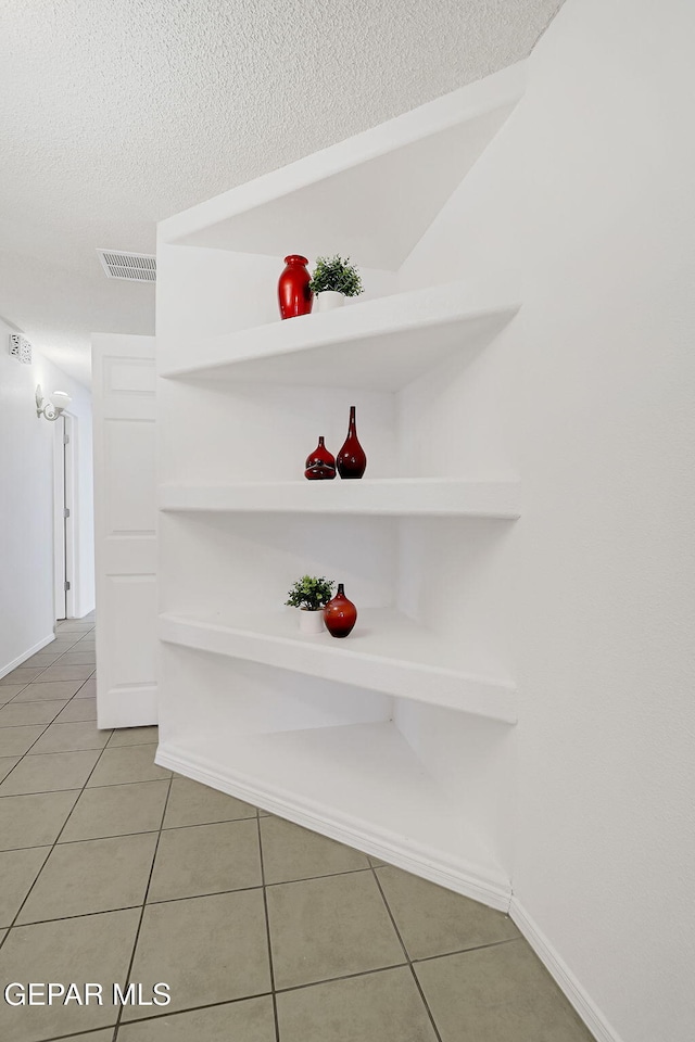 details with visible vents, baseboards, and a textured ceiling