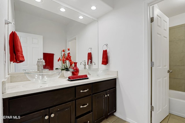 full bathroom with a sink, double vanity, and tile patterned floors