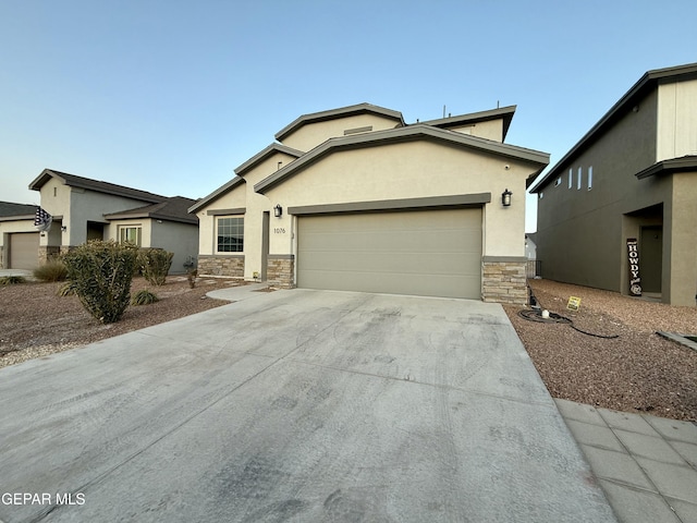 view of front of house with stucco siding, stone siding, driveway, and an attached garage