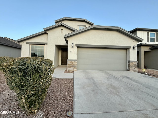 view of front of property featuring stone siding, stucco siding, driveway, and a garage