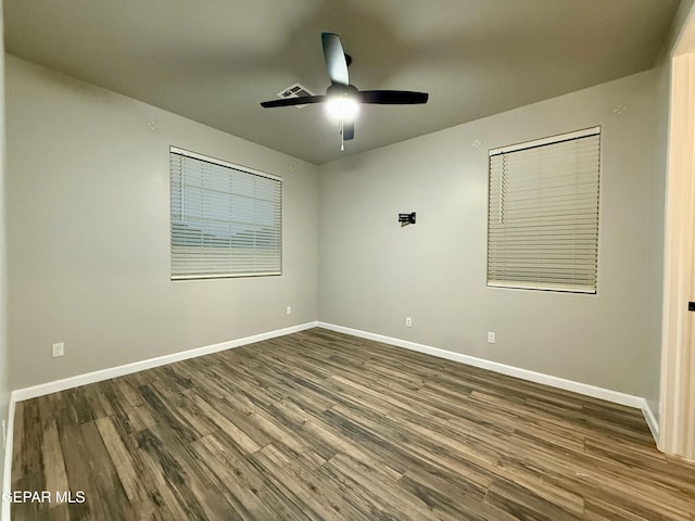 spare room with dark wood-style floors, baseboards, and ceiling fan