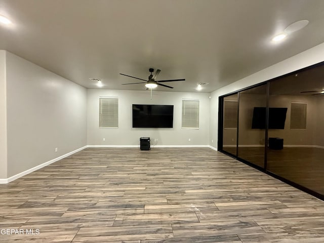 unfurnished living room featuring visible vents, baseboards, a ceiling fan, and wood finished floors