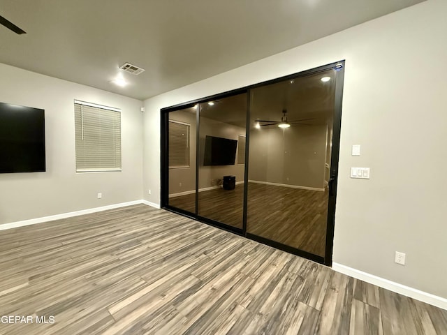 unfurnished bedroom with visible vents, baseboards, a closet, and wood finished floors