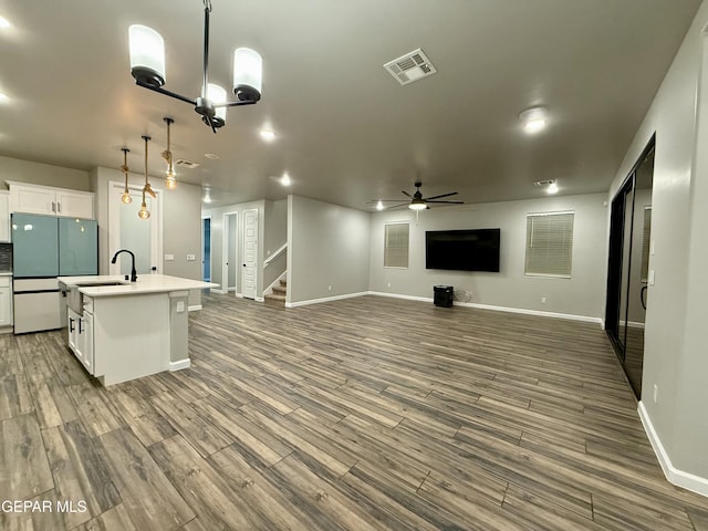 kitchen featuring open floor plan, white cabinetry, freestanding refrigerator, and wood finished floors