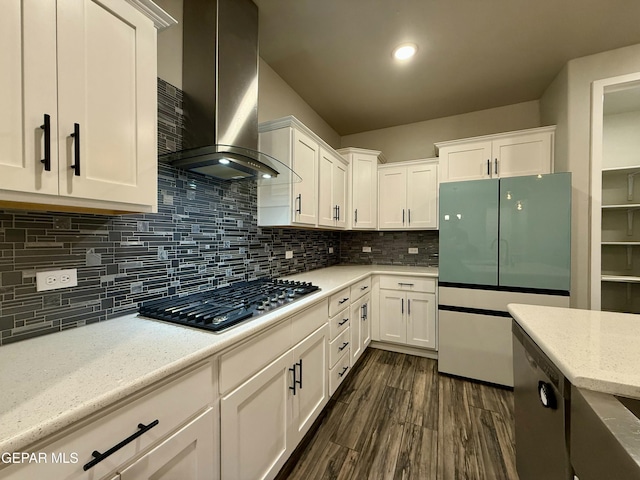 kitchen with stainless steel appliances, tasteful backsplash, wall chimney exhaust hood, and white cabinets