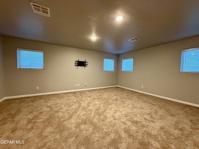 basement featuring visible vents, baseboards, and carpet flooring