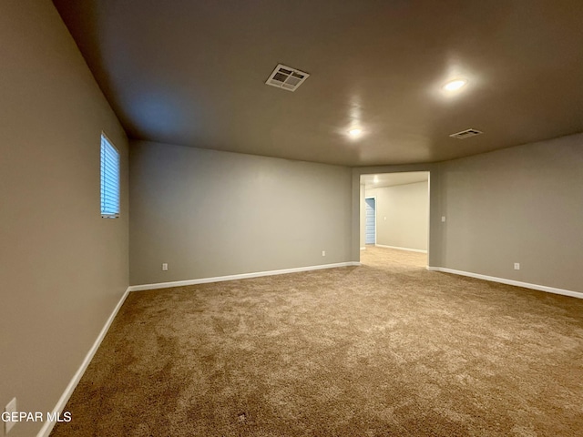 carpeted spare room featuring visible vents and baseboards