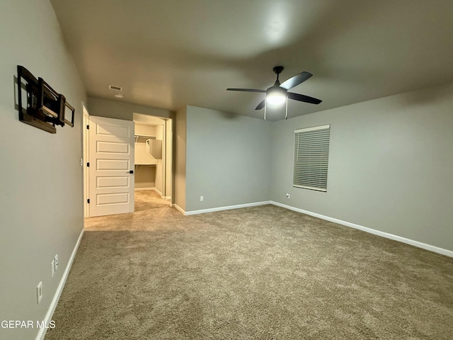 unfurnished bedroom with a spacious closet, baseboards, and carpet floors