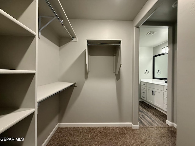 walk in closet with visible vents and dark colored carpet