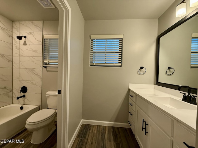 full bath with visible vents, toilet, wood finished floors, baseboards, and vanity