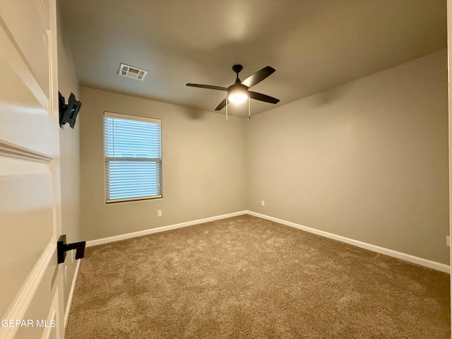 carpeted empty room with visible vents, baseboards, and a ceiling fan