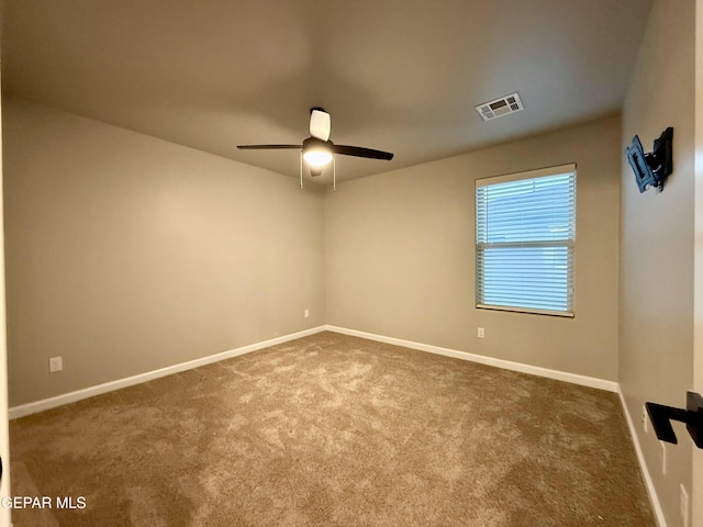 empty room with a ceiling fan, carpet, visible vents, and baseboards