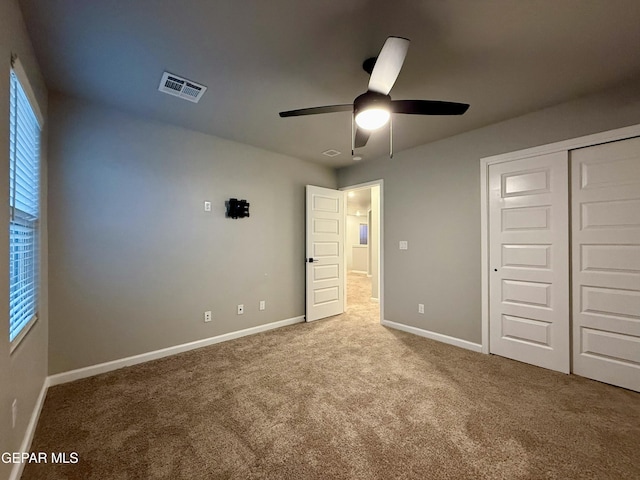 unfurnished bedroom with visible vents, baseboards, ceiling fan, carpet flooring, and a closet