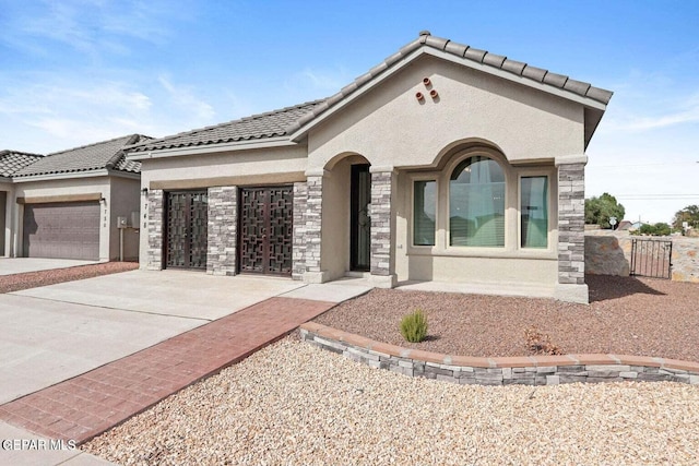 view of front of home with stucco siding, concrete driveway, an attached garage, and a tiled roof