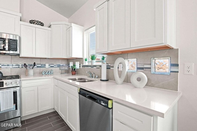 kitchen with decorative backsplash, appliances with stainless steel finishes, white cabinetry, and a sink