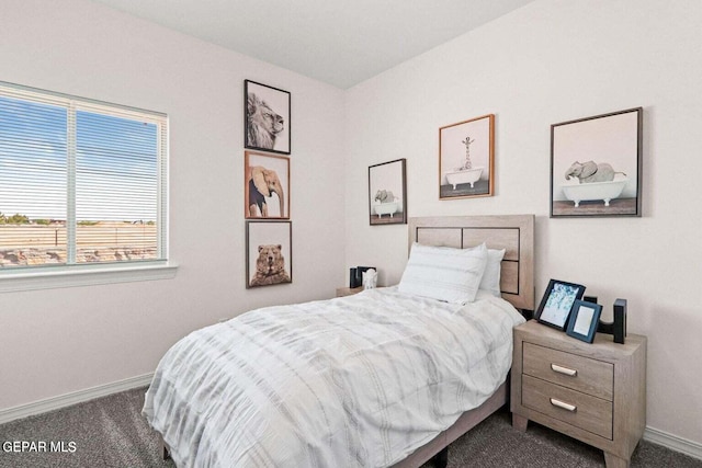 bedroom featuring baseboards and dark carpet