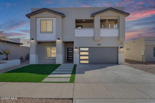 view of front of property with a garage, stucco siding, and a balcony