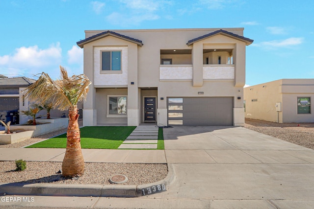 townhome / multi-family property with stucco siding, a balcony, a garage, and driveway