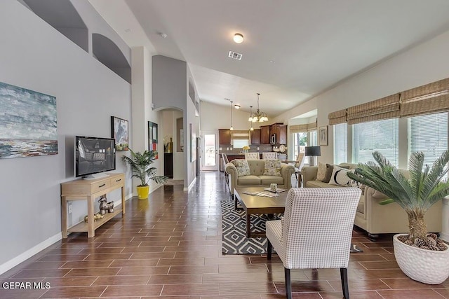 dining area featuring visible vents, baseboards, wood tiled floor, arched walkways, and a notable chandelier