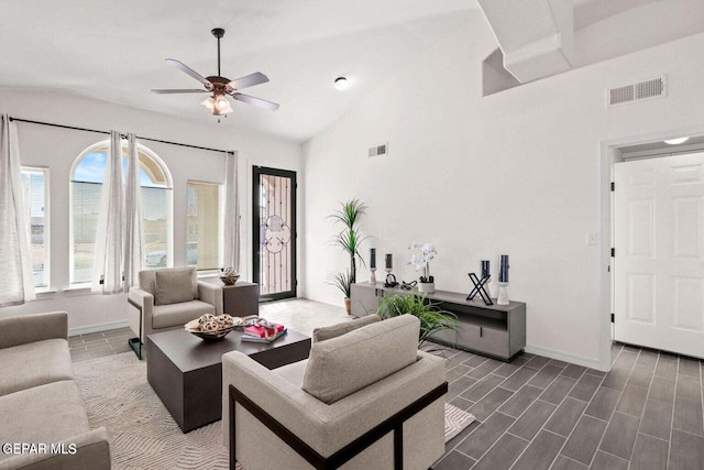 living room featuring visible vents, baseboards, ceiling fan, and vaulted ceiling