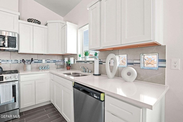 kitchen with a sink, decorative backsplash, white cabinets, and stainless steel appliances