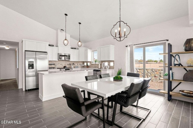 dining room with a notable chandelier, a healthy amount of sunlight, and wood tiled floor