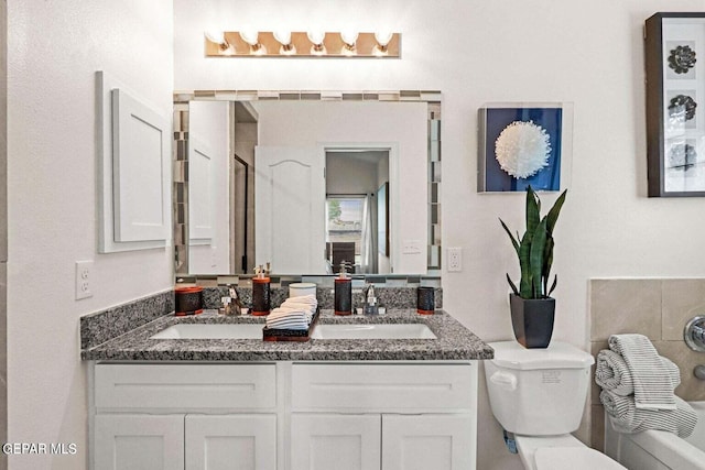 full bathroom featuring double vanity, toilet, and a sink