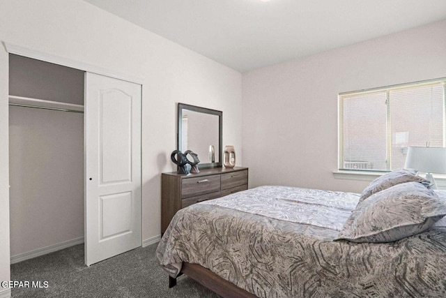 carpeted bedroom with a closet and baseboards