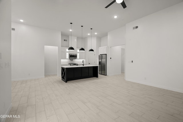 kitchen featuring visible vents, appliances with stainless steel finishes, open floor plan, and a ceiling fan