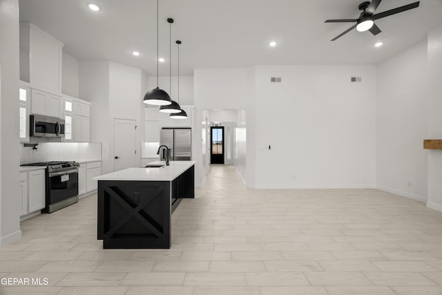 kitchen featuring visible vents, ceiling fan, stainless steel appliances, light countertops, and open floor plan