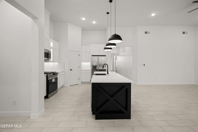 kitchen featuring decorative light fixtures, light countertops, appliances with stainless steel finishes, white cabinets, and a sink