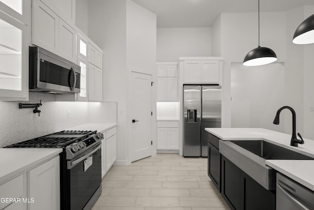 kitchen featuring backsplash, white cabinetry, stainless steel appliances, and light countertops