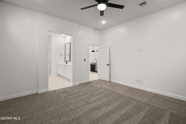 spare room with visible vents, light colored carpet, baseboards, and a ceiling fan