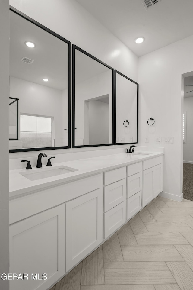 bathroom featuring double vanity, visible vents, recessed lighting, and a sink