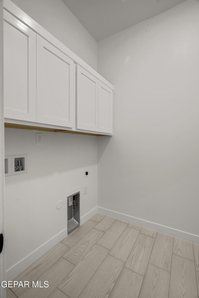 washroom with hookup for an electric dryer, cabinet space, baseboards, gas dryer hookup, and hookup for a washing machine