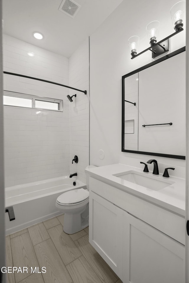 bathroom with visible vents, toilet, vanity, and bathtub / shower combination