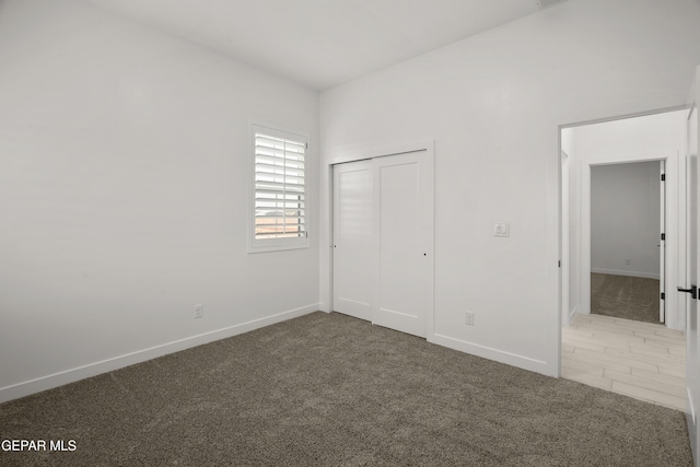 unfurnished bedroom with a closet, baseboards, and carpet floors