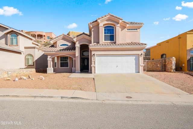 mediterranean / spanish-style home featuring fence, a tile roof, concrete driveway, stucco siding, and a garage