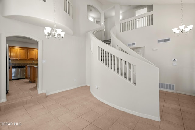 stairway featuring tile patterned flooring, visible vents, and a chandelier