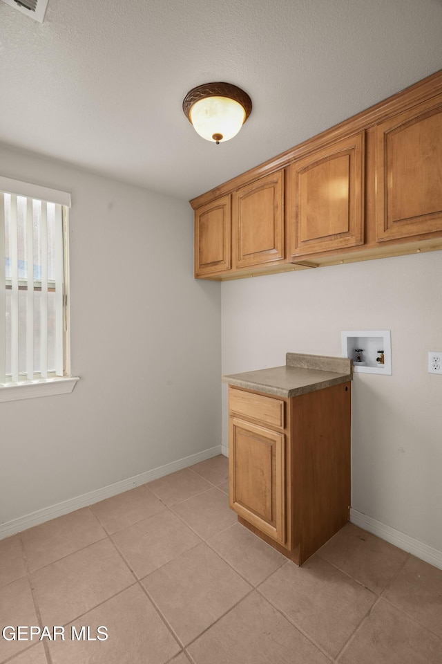 laundry room with light tile patterned floors, cabinet space, baseboards, and washer hookup