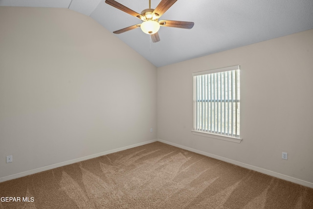 empty room with baseboards, lofted ceiling, carpet, and a ceiling fan