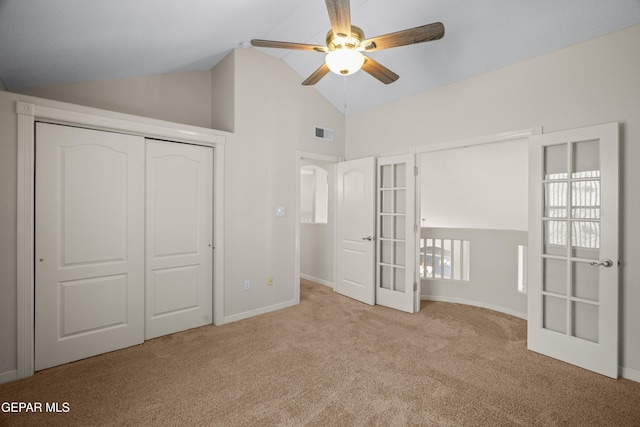 unfurnished bedroom with visible vents, lofted ceiling, a closet, carpet, and baseboards