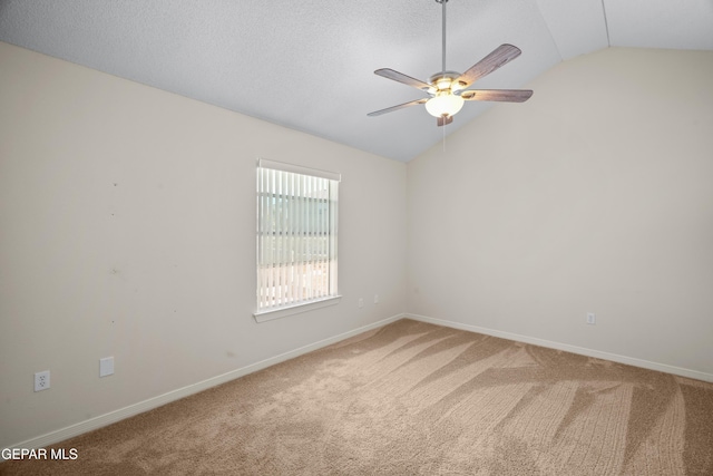 carpeted empty room featuring baseboards, lofted ceiling, a textured ceiling, and a ceiling fan