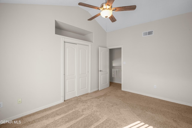 unfurnished bedroom with baseboards, visible vents, vaulted ceiling, a closet, and carpet flooring