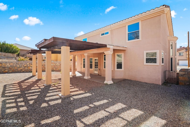 back of house with stucco siding and a patio